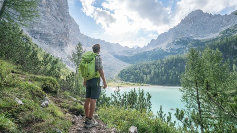 Young man contemplating nature by the mountain lake in Alto Adige in South Tyrol region, Italy